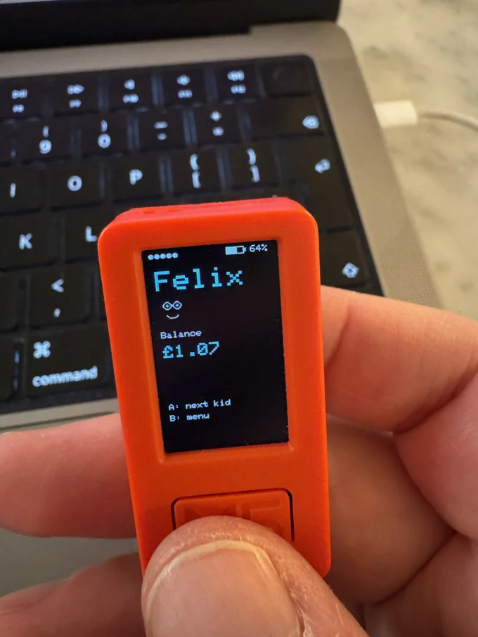 Device showing Felix's balance (£1.07) with 'next kid' and 'menu' options